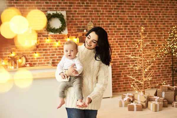 Una hermosa madre joven con un bebé en una Navidad decorada ro — Foto de Stock