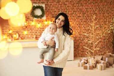 Noel süslemeli bir Ro 'da bebeği olan güzel genç bir anne.