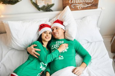 Mutlu, genç, romantik, beyaz bir çift pijama giyer, eğlenir.