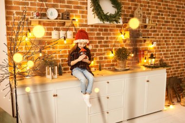 Noel süslemeli bir evde küçük bir kızın portresi. 