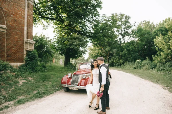 Весілля розкішна наречена і красивий наречений в ретро автомобілі біля — стокове фото