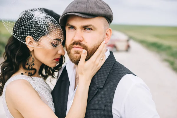 Casal elegante, noiva, noivo andando em uma estrada de campo nea — Fotografia de Stock