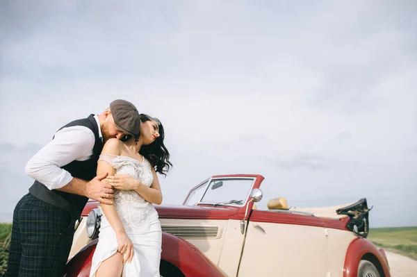 Elegante coppia di nozze, sposa, sposo su una strada di campo vicino retrò — Foto Stock