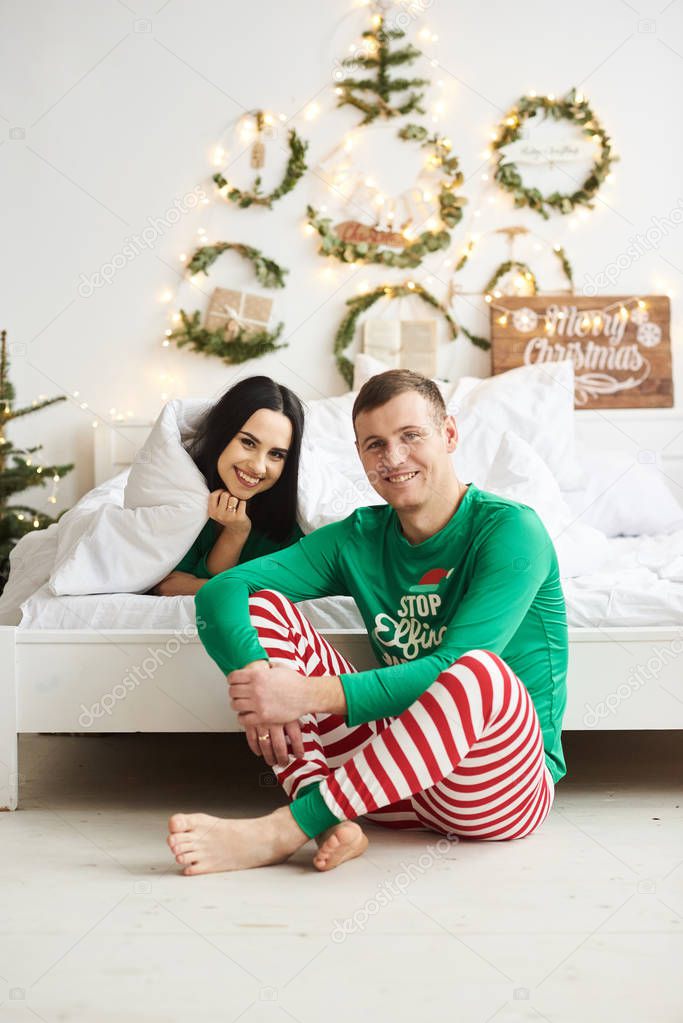 Happy young romantic caucasian couple wear pajamas having fun la