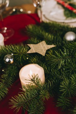 Yanan mumlar ve Noel süslemeleri olan şık bir masa.