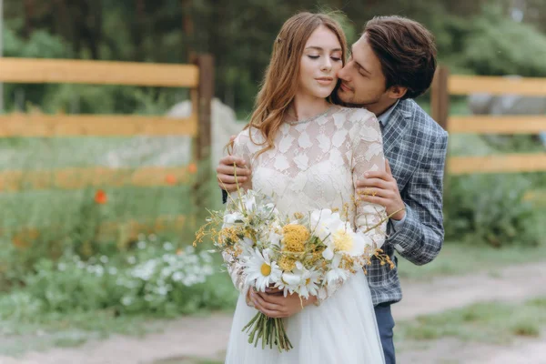 Un jeune couple de mariées s'amusent et marchent dans le champ — Photo