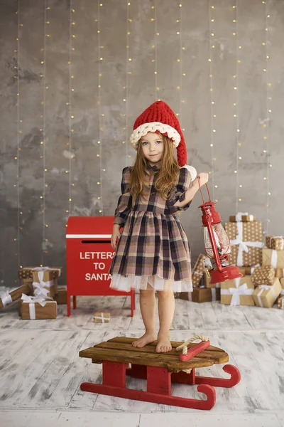 Een portret van mooi kind zittend op de slee op geschenken terug — Stockfoto
