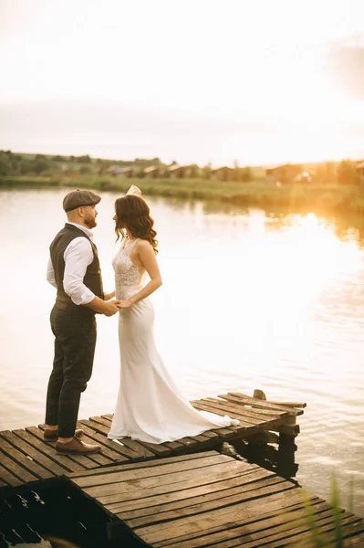 Elegante pareja de boda retro, novia, novio caminando en un campo ne —  Fotos de Stock