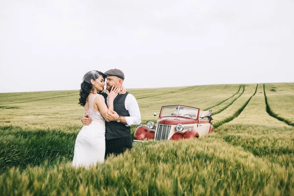 Стильна весільна пара, наречена, наречений в зеленому полі поблизу retr — стокове фото