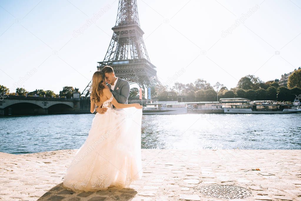 Happy romantic married couple hugging near the Eiffel tower in P