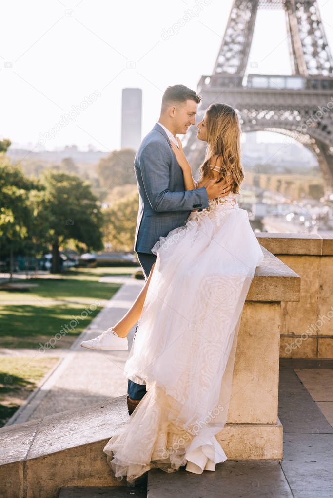 Happy romantic married couple hugging near the Eiffel tower in P