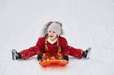 Bir portre, kızağın üzerindeki beyaz bir çocuk.