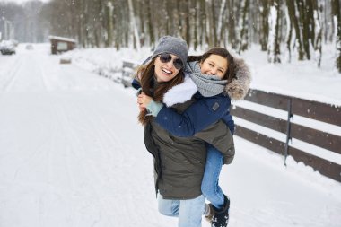 Genç bir anne ve ağaç çocuğu eğleniyor ve oyun oynuyorlar.