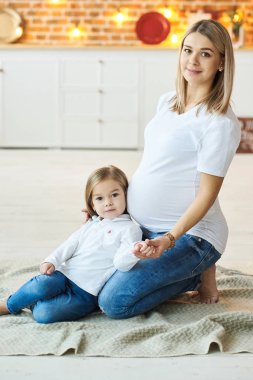 Hamile annesiyle birlikte küçük bir kızın portresi. 