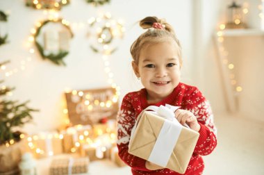 Kırmızı Noel süveteri giymiş güzel bir kızın portresi.
