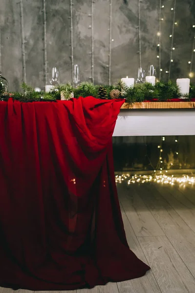 Stylish red table setting with burning candles and Christmas dec
