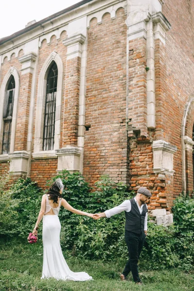Ретро весілля пара, наречена, наречений ходить біля старого цегляного патрона — стокове фото