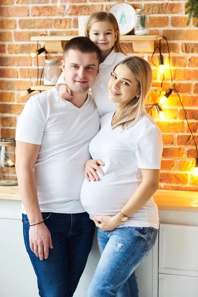 Eine junge Familie, Vater, schwangere Mutter und ihre kleine Tochter — Stockfoto