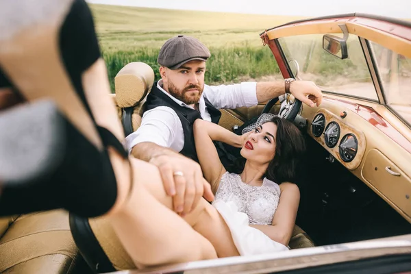 Elegante pareja de boda, novia, novio abrazándose en coche retro . —  Fotos de Stock