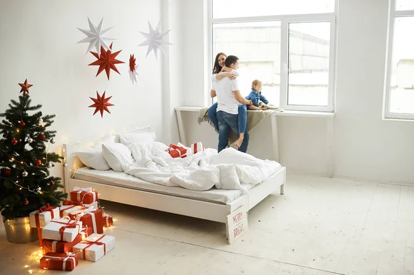 Mutlu aile anne baba ve çocuk Noel sabahı yatakta — Stok fotoğraf
