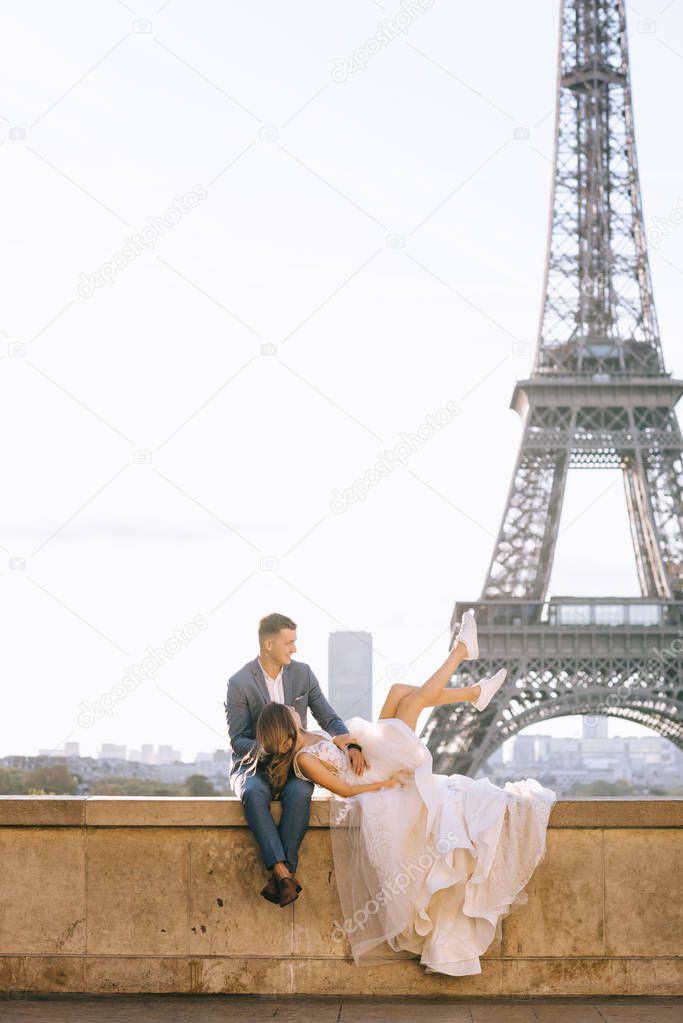 Happy romantic married couple hugging near the Eiffel tower in P