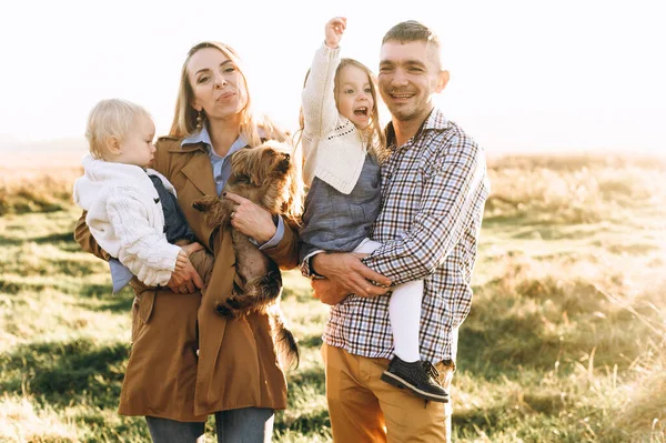 Famille heureuse jouant dans le champ vert — Photo