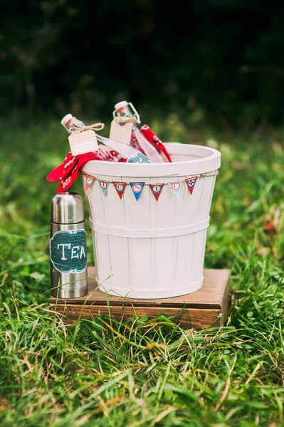 Cubo de madera decorativo con botellas de vidrio y termos con té en un soporte de madera. — Foto de Stock