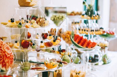 Düğün büfesinde farklı taze meyveler. Düğün masası dekorasyonu. Büfe karşılama meyveleri.