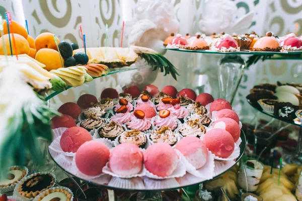 Various colored delicious sweets in a candy bar at a wedding. Sweet table. Wedding buffet. — Stock Photo, Image