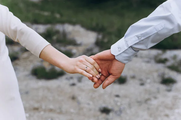 Feche o par de casamento de mãos dadas ao ar livre. Fundo desfocado. — Fotografia de Stock