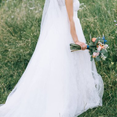 Gelinin elinde gelinlik giymiş güzel bir düğün buketi. Çiçek aranjmanı.