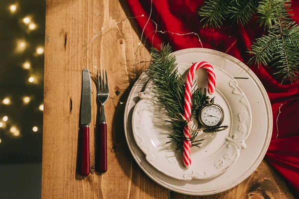 Mesa de Año Nuevo con un mantel rojo, utensilios antiguos y un reloj vintage. — Foto de Stock