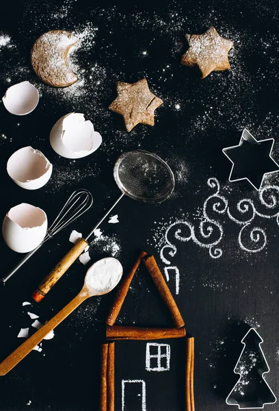 Casa de canela en la mesa se complementa con un patrón de tiza y utensilios para hacer galletas. — Foto de Stock