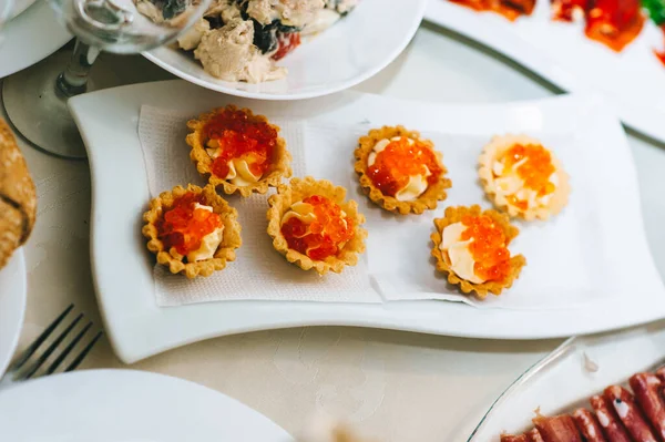 Fechar de tortinhas apetitosas com caviar em uma chapa branca. — Fotografia de Stock