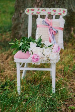 Taze şakayıklı bahçe süslemesi. Sandalyede pembe bir retro..