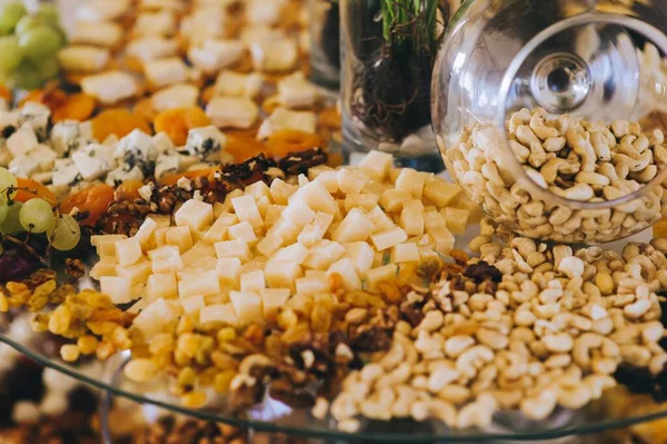 Primer plano de varios tipos de queso, nueces y cacahuetes en una mesa de banquete. — Foto de Stock