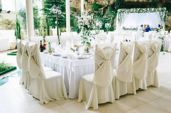 Nakrycie stołu na weselu w pastelowych kolorach zdobią kwiaty i zabytkowy świecznik. — Zdjęcie stockowe