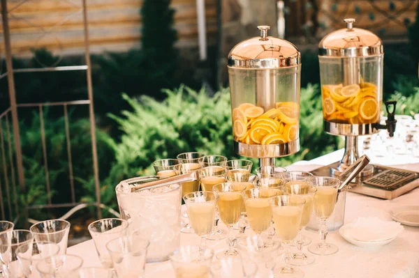 Frascos de vidrio de limonada con cítricos en rodajas sobre una mesa buffet. — Foto de Stock