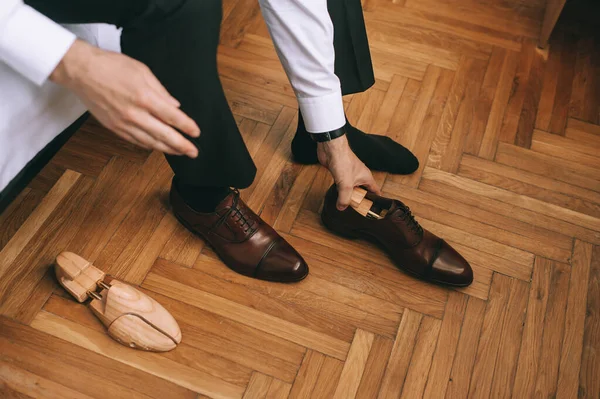 Закрыть ноги ухажеру или бизнесмену, надевающему новую стильную обувь. — стоковое фото