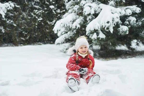 Retrato de un hermoso niño caucásico sobre un fondo de árboles de Navidad cubiertos de nieve — Foto de Stock