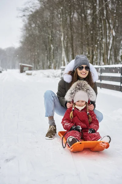 Eine junge schöne Mutter schlittert ihr Baby — Stockfoto