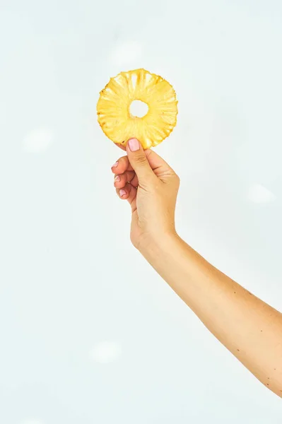 Female hand holding pineapple fruit chips on a white background. — Stock Photo, Image