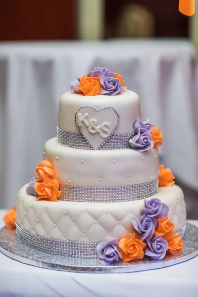 White multi level wedding cake with orange lilies flower decorations