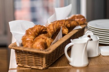 Gri ahşap masada taze pişmiş kruvasanlar.