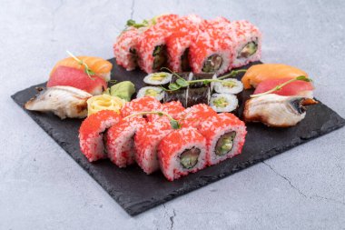 Suşi Sashimi ve suşi ruloları taş levhada servis edilir.
