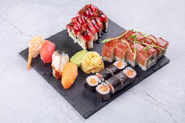 Suşi Sashimi ve suşi ruloları taş levhada servis edilir.
