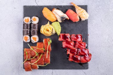 Suşi Sashimi ve suşi ruloları taş levhada servis edilir.