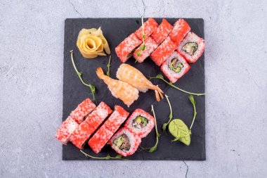 Suşi Sashimi ve suşi ruloları taş levhada servis edilir.