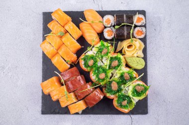 Suşi Sashimi ve suşi ruloları taş levhada servis edilir.