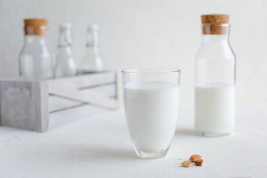 Şişe ve bardak taze süt. Badem veya inek süt. Beyaz arka plan.